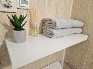 a stack of towels on a white shelf in a bathroom at Ultra central medieval apartment in Cluj-Napoca