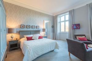 una camera da letto con un letto e una sedia di Hôtel Château de Didonne a Royan