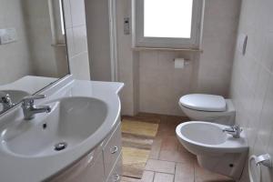 uma casa de banho branca com um lavatório e um WC em Sweet Cecina Mare em Cecina