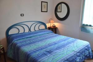 um quarto com uma cama com um edredão azul e um espelho em Sweet Cecina Mare em Cecina