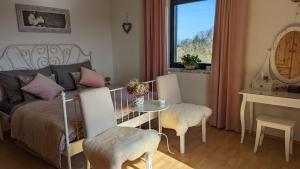 a bedroom with a bed and a table and a window at Ursteirerhof - Familie Kerschbaumer in Palsdorf