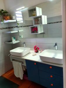 a bathroom with two sinks and two mirrors at Chambre chez l'habitant à L' Amirade chez Michelle in Grande Anse