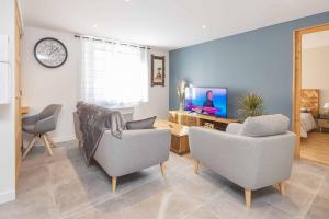 salon z 2 krzesłami i telewizorem w obiekcie Appartement Modane Wifi stationnement gratuit w mieście Modane