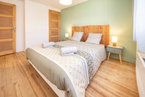 een slaapkamer met een groot bed en 2 handdoeken bij Appartement Modane Wifi stationnement gratuit in Modane