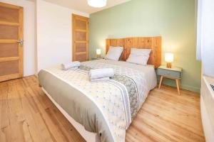 sypialnia z dużym łóżkiem z dwoma ręcznikami w obiekcie Appartement Modane Wifi stationnement gratuit w mieście Modane