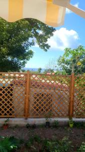 een houten hek in een tuin bij Chambre chez l'habitant à L' Amirade chez Michelle in Grande Anse