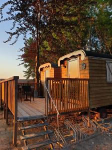 een houten hut met een veranda en een terras bij Bed & Breakfast ARKEN AE in Zuiderwoude