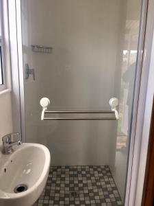 y baño con lavabo y cabina de ducha. en Fynbos Tiny Home - Off Grid, Surrounded by Nature en Plettenberg Bay