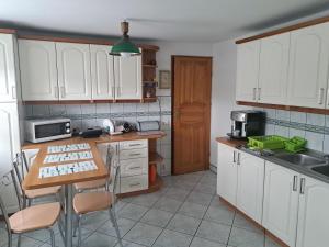 a kitchen with white cabinets and a wooden table at Mieszkanie na wyłączność in Jeleśnia