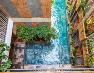 a pool in a building with a fountain at Daisy Boutique Hotel in Da Nang