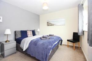 a bedroom with a bed with a blue blanket at Hidden Gem of Newark - Sleeps 6 in Ollerton