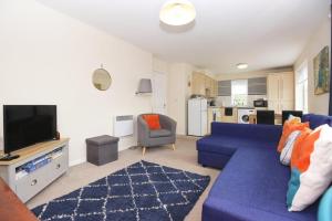 a living room with a blue couch and a tv at Hidden Gem of Newark - Sleeps 6 in Ollerton
