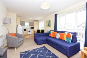 uma sala de estar com um sofá azul e uma cadeira em Hidden Gem of Newark - Sleeps 6 em Ollerton