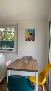 een eetkamer met een houten tafel en gele stoelen bij Appartement proche de la mer in La Garde