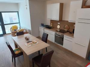 a kitchen and dining room with a table and chairs at TINA Apartments in Černá v Pošumaví