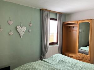 1 dormitorio con cama, ventana y corazones en la pared en Gästehaus „Bei Emmi“, en Lichtenberg