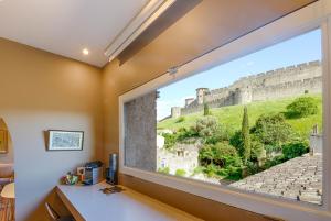 een kamer met een raam met uitzicht op het kasteel bij Pelletier du Claux in Carcassonne