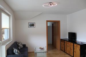 uma sala de estar com um sofá e uma televisão em Apartment ZIRMWEBER-Haus em Sankt Johann im Pongau