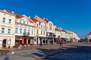 a city street with buildings and people walking on the street at Apartament e-Space in Rzeszów