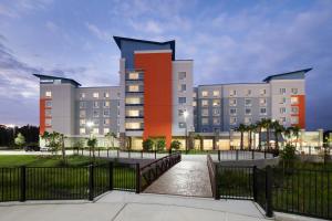 a large building with a fence in front of it at TownePlace Suites by Marriott Orlando at SeaWorld in Orlando