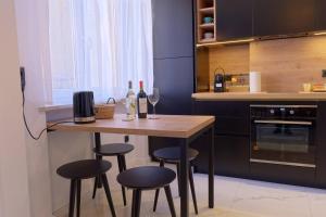 a kitchen with a wooden table with two bottles of wine at Apartament e-Space in Rzeszów