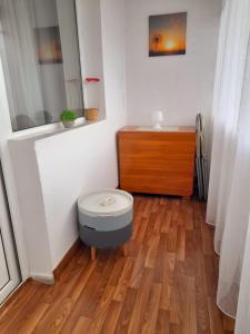 baño con aseo y suelo de madera en Apartament Modern Family, en Târgu Ocna