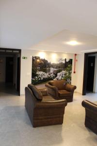 a lobby with two couches and a painting on the wall at Hotel San Lucas in Gramado