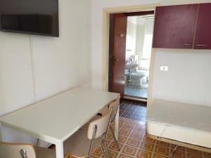 切塞納蒂科的住宿－BILOCALE Villa Gioello，厨房配有桌子和白色冰箱。