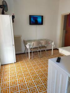 uma sala de estar com uma mesa e uma televisão na parede em BILOCALE Villa Gioello em Cesenatico