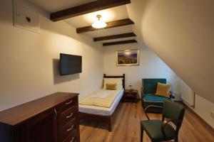 mały pokój z łóżkiem i krzesłem w obiekcie Vila Magnolia w Bańskiej Szczawnicy