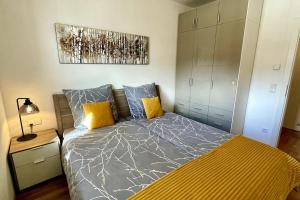 1 dormitorio con 1 cama con almohadas azules y amarillas en Apartment Hucklehaus, en Aich