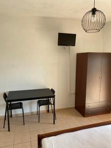 a living room with a table and a tv at Sofia studios in Nea Skioni