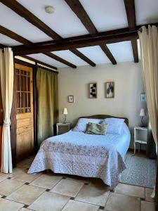 um quarto com uma cama com um edredão azul em Le Petit Bois Normand em Champ-du-Boult