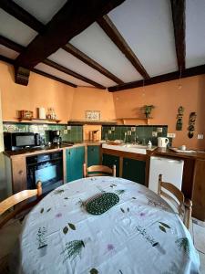 uma cozinha com uma mesa e uma cozinha com em Le Petit Bois Normand em Champ-du-Boult