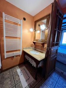 uma casa de banho com um lavatório e um espelho em Le Petit Bois Normand em Champ-du-Boult