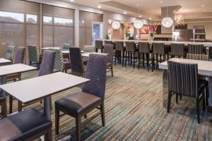 Residence Inn by Marriott Decatur في ديكاتور: غرفة طعام مع طاولات وكراسي وبار