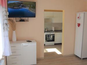 a kitchen with a tv hanging on the wall at Apartamenty Anagora Kotlina Kłodzka I in Nowa Ruda