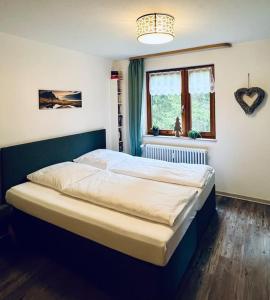 ein großes Bett in einem Schlafzimmer mit Fenster in der Unterkunft Waldtwin 2 Titisee (W12) + Hochschwarzwald Card in Titisee-Neustadt