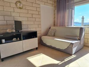 un soggiorno con divano e TV di Apartmani Beba a Trogir