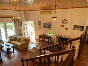 Villa Aris في أوليمبيا: غرفة معيشة مع أريكة ومدفأة