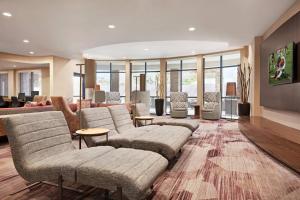 una sala de estar con sofás, mesas y ventanas en Courtyard by Marriott Sacramento Folsom, en Folsom