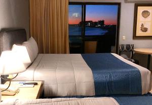 a hotel room with a bed and a desk and a window at Peñasco del Sol Hotel in Puerto Peñasco