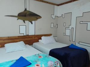 two beds in a room with a shark on the wall at Ocean Way Guraidhoo in Guraidhoo