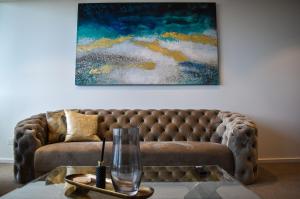 a couch in a living room with a painting on the wall at Deluxe 3 Bedroom 2 Bathroom Apt Southbank in Melbourne