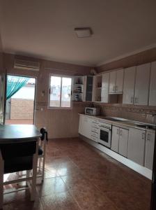 a kitchen with white cabinets and a table in it at Reina Amalia in Quintanar de la Orden
