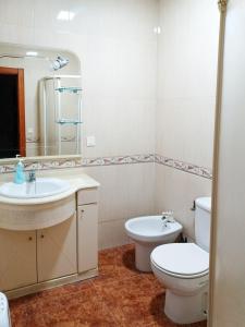 a bathroom with a sink and a toilet and a mirror at Reina Amalia in Quintanar de la Orden