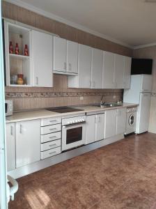 a kitchen with white cabinets and a white refrigerator at Reina Amalia in Quintanar de la Orden