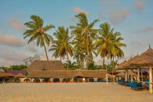 a beach with palm trees and a resort at Best Western Jangwani Sea Breeze Resort in Dar es Salaam