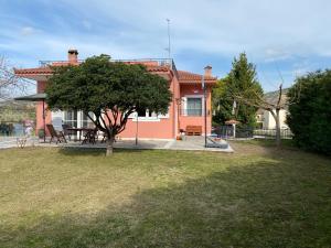 una casa roja con un árbol en el patio en Villa Aris en Olympia