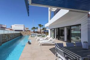 - une piscine avec des chaises longues à côté d'un bâtiment dans l'établissement La casa del sol villa de luxe, à Ciudad Quesada